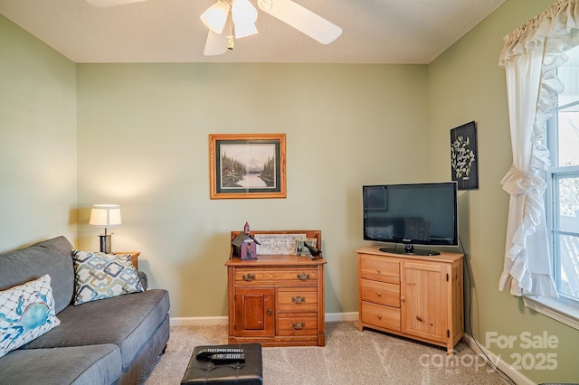 living room featuring light colored carpet, ceiling fan, and baseboards