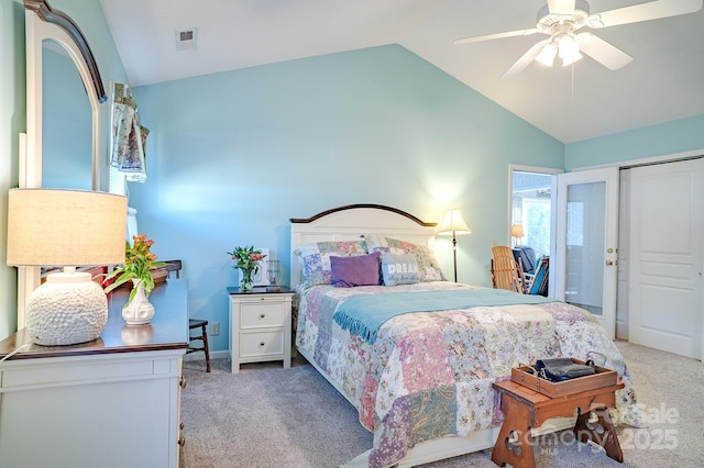 carpeted bedroom with a closet, vaulted ceiling, and ceiling fan