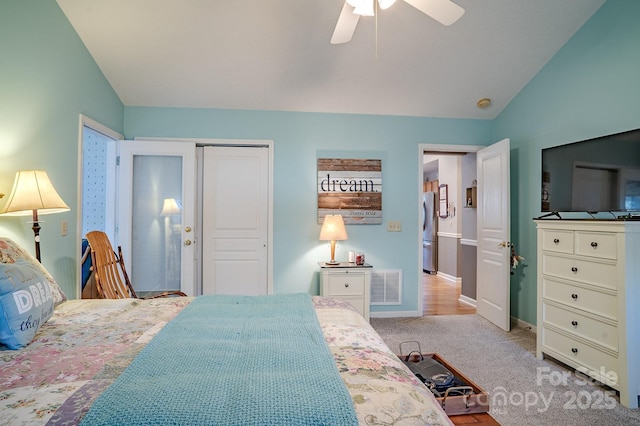 bedroom with lofted ceiling, visible vents, a closet, and freestanding refrigerator