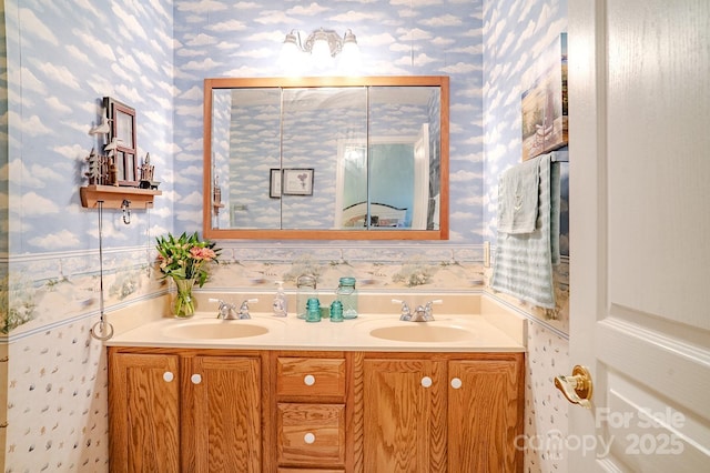 bathroom featuring double vanity, a sink, and wallpapered walls