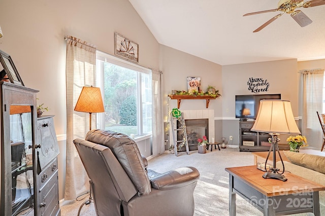 living room with carpet, ceiling fan, high vaulted ceiling, a tile fireplace, and baseboards