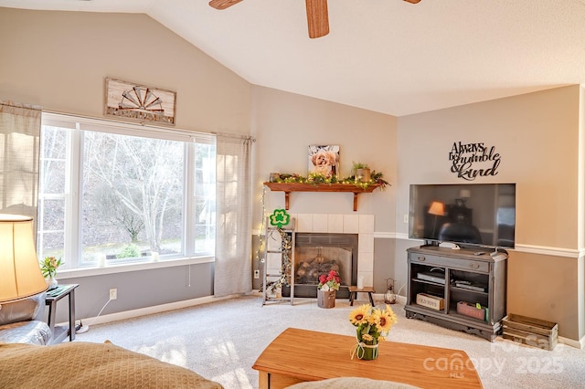 living area with lofted ceiling, ceiling fan, baseboards, and a tiled fireplace