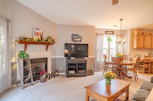 carpeted living room with a chandelier, a fireplace, and baseboards