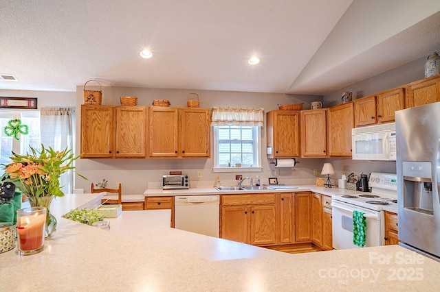 kitchen with recessed lighting, white appliances, light countertops, and a sink