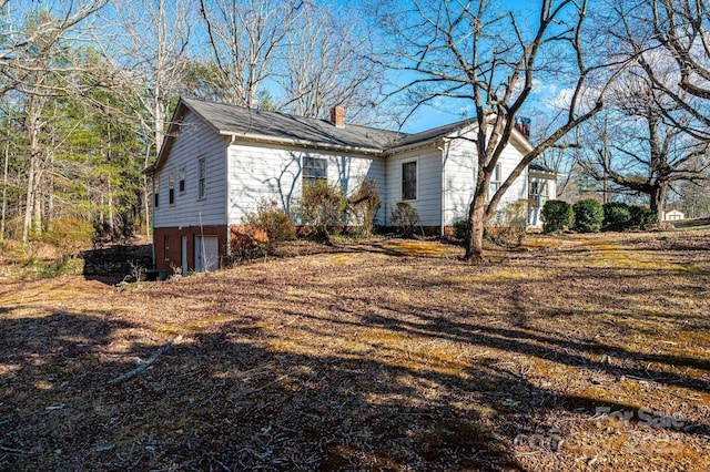 exterior space with a chimney and an attached garage