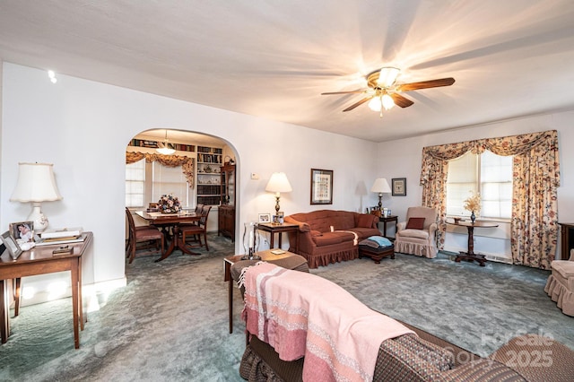 living room with arched walkways and carpet flooring