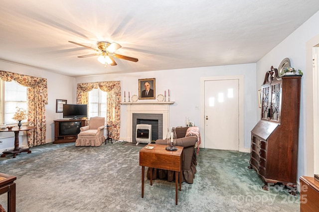 living area with a ceiling fan and dark colored carpet