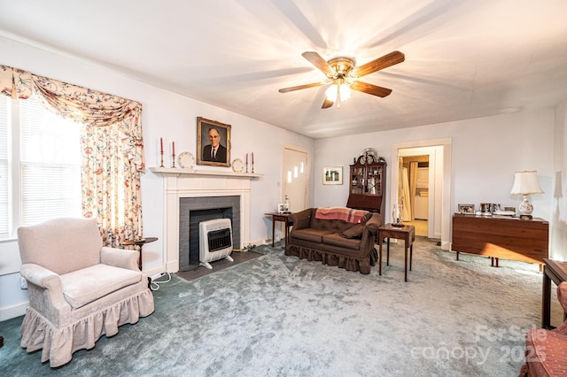 carpeted living room with baseboards, ceiling fan, and heating unit