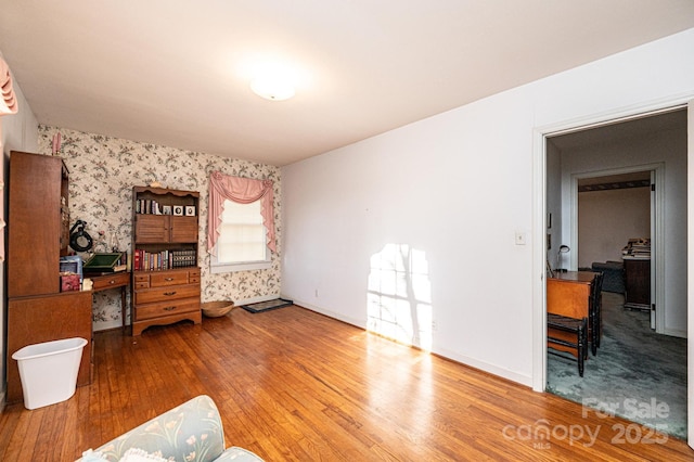 bedroom with wallpapered walls, baseboards, and wood finished floors