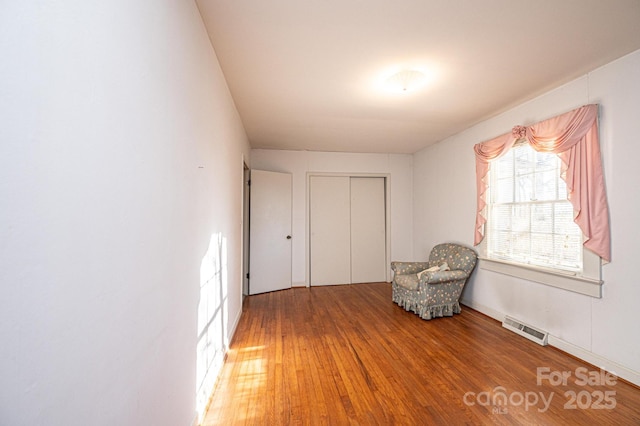 unfurnished room with visible vents and wood finished floors