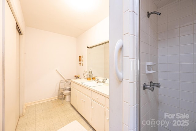 full bath featuring toilet, tile patterned floors, tiled shower, and vanity