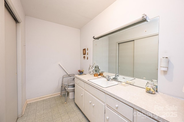 bathroom featuring toilet, tile patterned floors, baseboards, and vanity