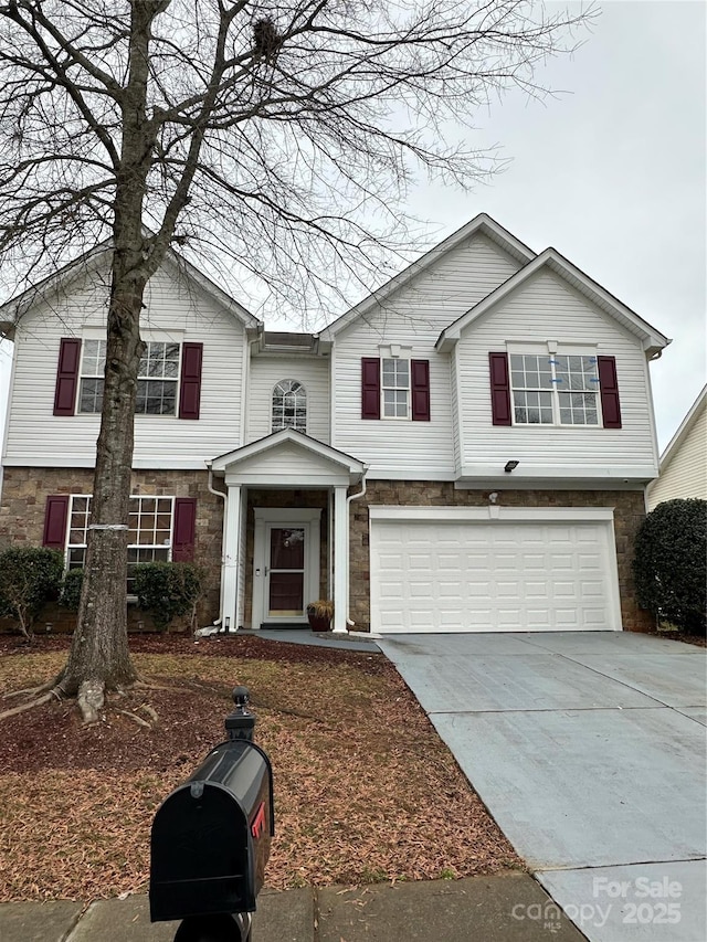 view of front of home featuring a garage, stone siding, and concrete driveway