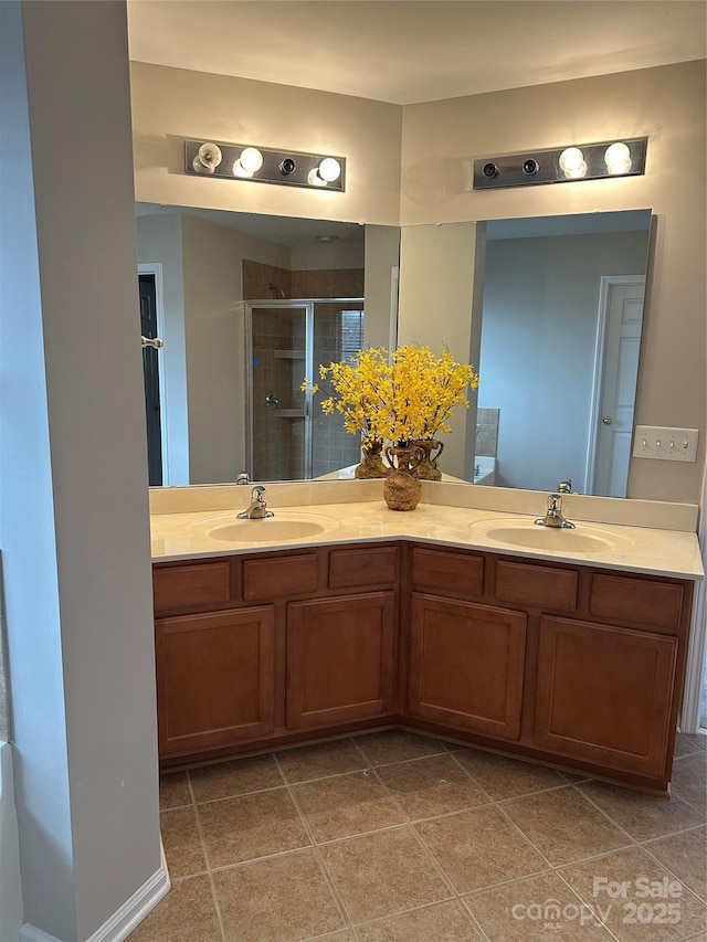 full bath featuring double vanity, a shower stall, a sink, and tile patterned floors