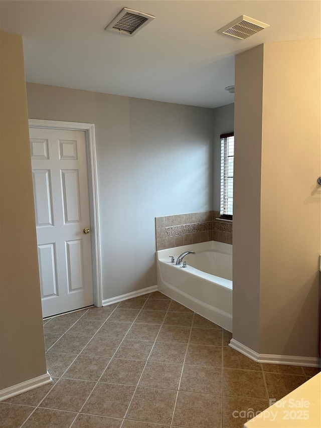 bathroom featuring tile patterned flooring, visible vents, baseboards, and a bath