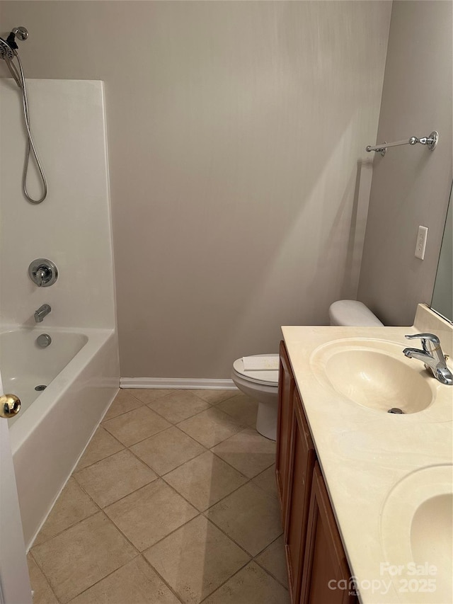 bathroom featuring double vanity, baseboards, toilet, tile patterned flooring, and a sink