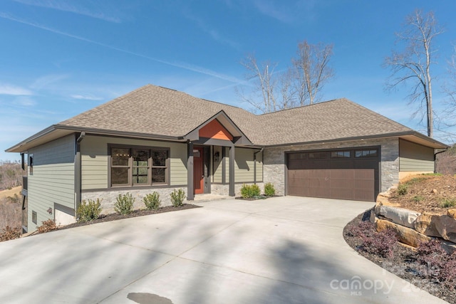 view of front facade featuring stone siding, roof with shingles, driveway, and an attached garage