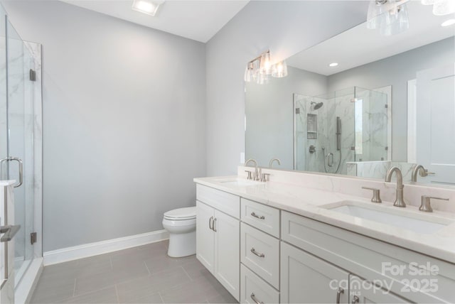 bathroom featuring a marble finish shower, baseboards, a sink, and toilet