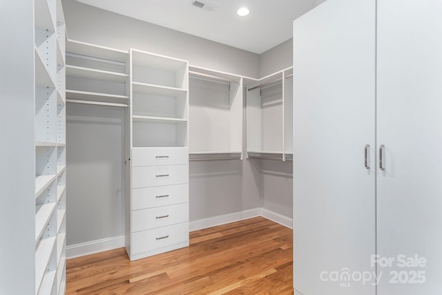 spacious closet with light wood-style floors and visible vents