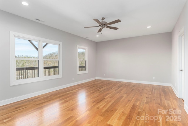 empty room with light wood-style floors, recessed lighting, and baseboards