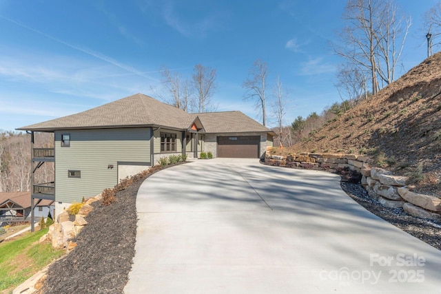 single story home with a garage, driveway, and a balcony