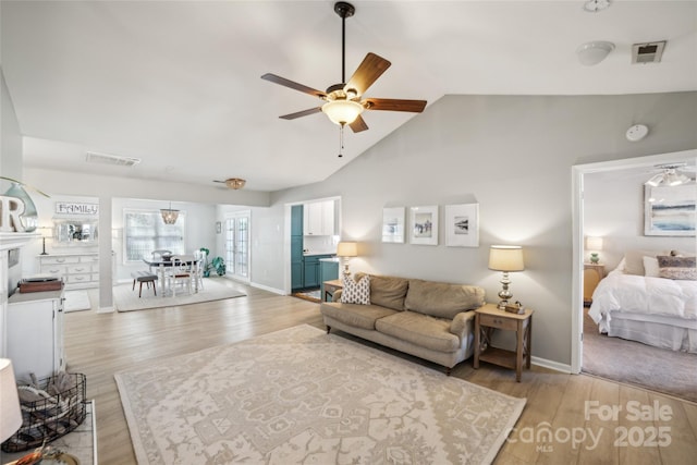 living area featuring lofted ceiling, ceiling fan, light wood-type flooring, and visible vents