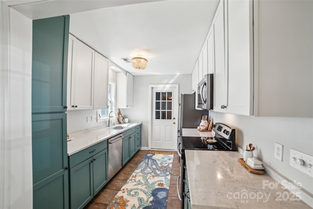 kitchen featuring appliances with stainless steel finishes, white cabinets, a sink, and green cabinets