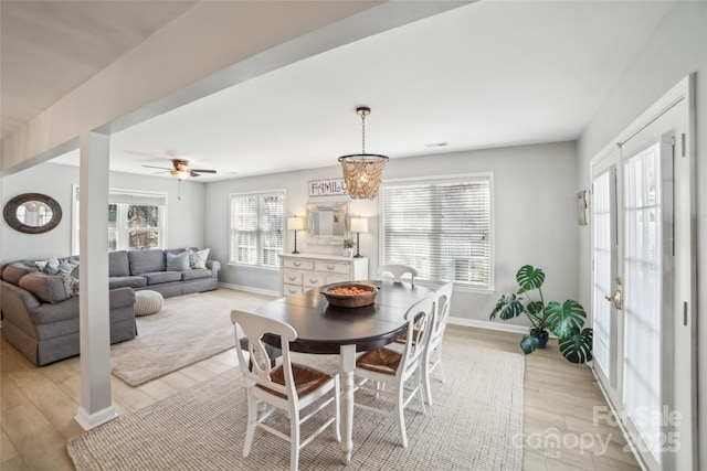 dining room with light wood-style floors, ceiling fan, visible vents, and baseboards