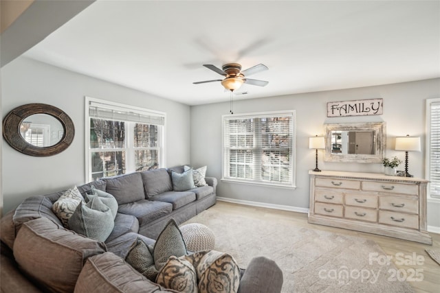 living room with light wood-style floors, a healthy amount of sunlight, ceiling fan, and baseboards