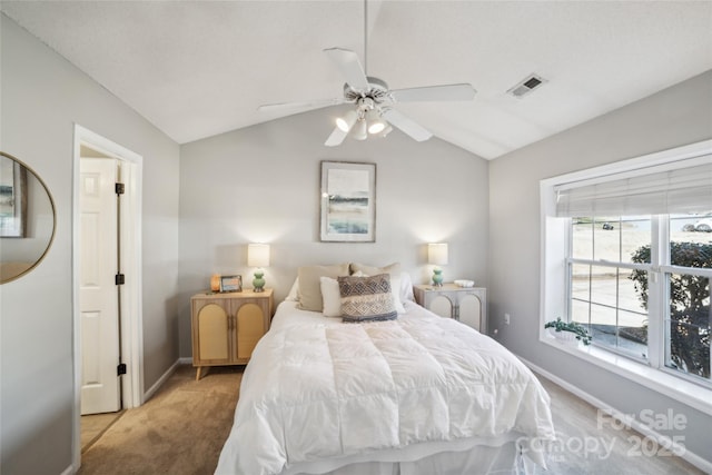 carpeted bedroom featuring a ceiling fan, lofted ceiling, visible vents, and baseboards