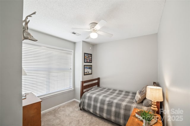 bedroom with carpet floors, visible vents, ceiling fan, a textured ceiling, and baseboards