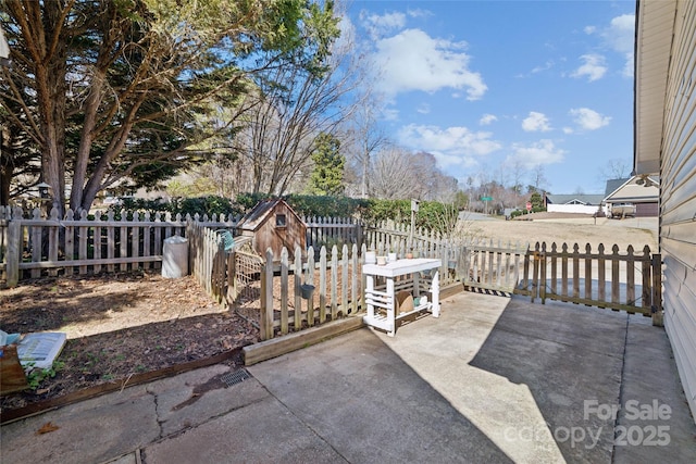 view of patio / terrace with a fenced backyard and an outdoor structure