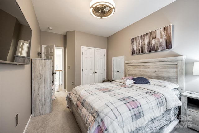 bedroom with baseboards, a closet, and light colored carpet