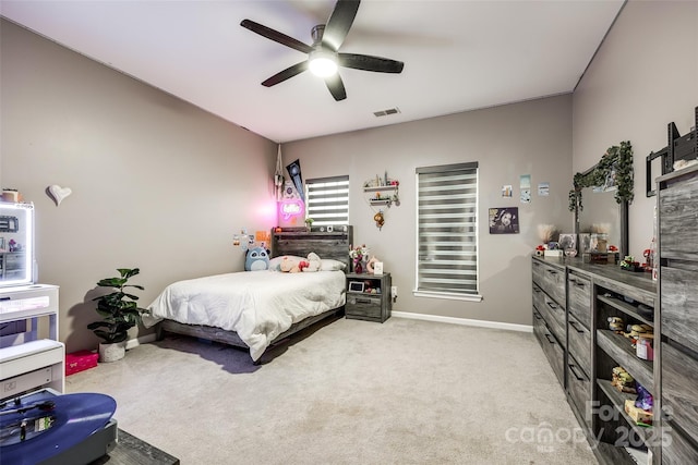 bedroom with light carpet, ceiling fan, visible vents, and baseboards