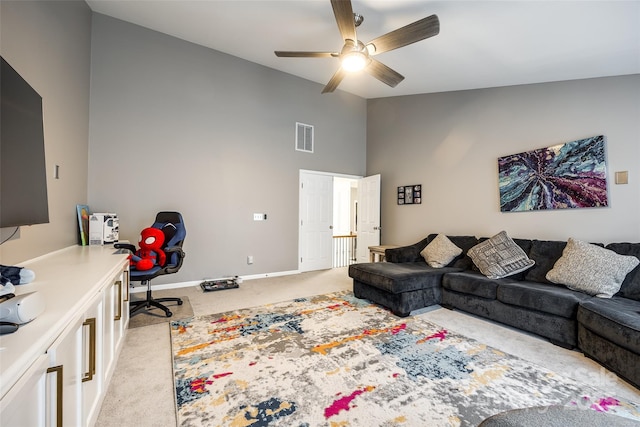 living room featuring ceiling fan, light colored carpet, visible vents, baseboards, and vaulted ceiling