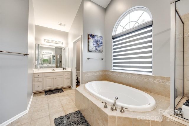 bathroom featuring visible vents, toilet, tile patterned floors, a garden tub, and vanity