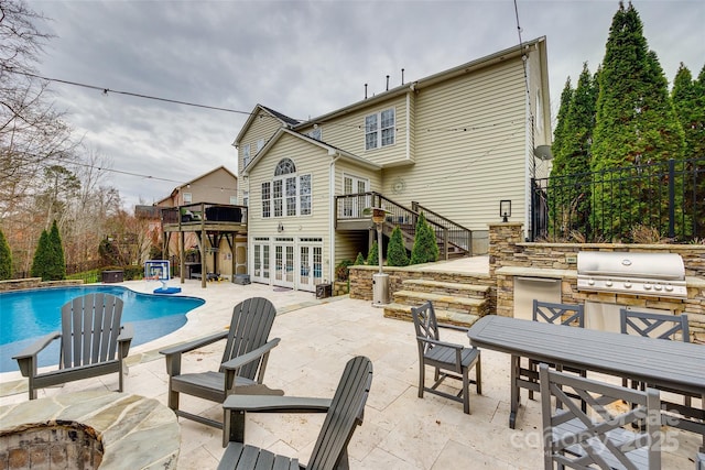 exterior space featuring a patio, grilling area, stairs, exterior kitchen, and french doors