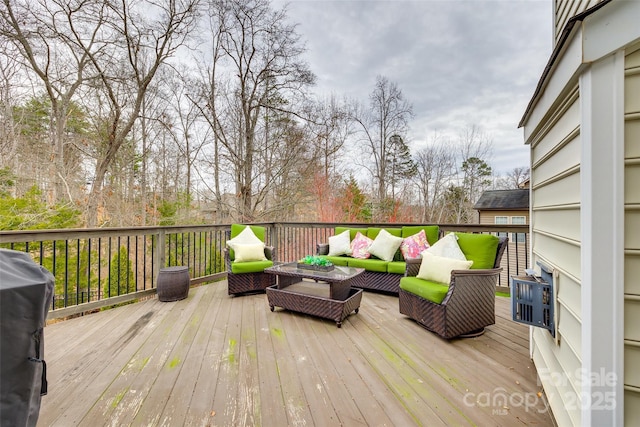 wooden terrace featuring a grill and an outdoor living space