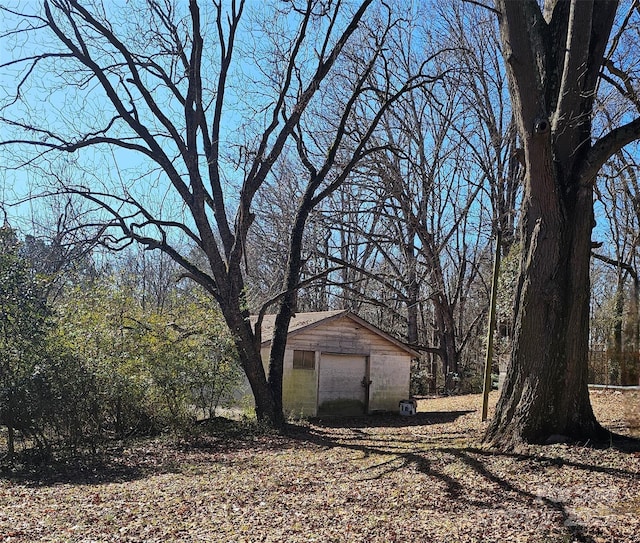 view of yard with a detached garage and an outbuilding