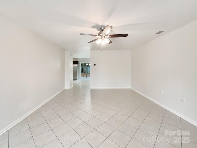 empty room with a ceiling fan, visible vents, baseboards, and light tile patterned floors