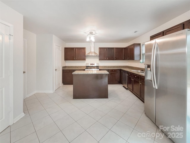 kitchen with a center island, light countertops, appliances with stainless steel finishes, dark brown cabinetry, and wall chimney exhaust hood