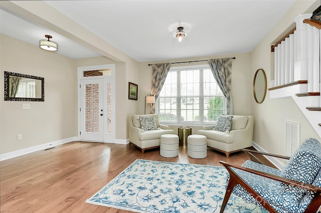 living area with visible vents, baseboards, and wood finished floors