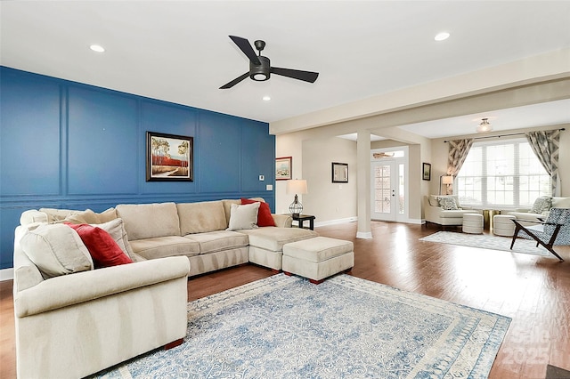 living area featuring a ceiling fan, wood finished floors, recessed lighting, a decorative wall, and baseboards