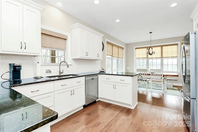 kitchen with light wood-type flooring, appliances with stainless steel finishes, and white cabinets