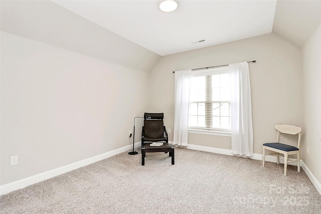 sitting room with visible vents, carpet flooring, baseboards, and vaulted ceiling