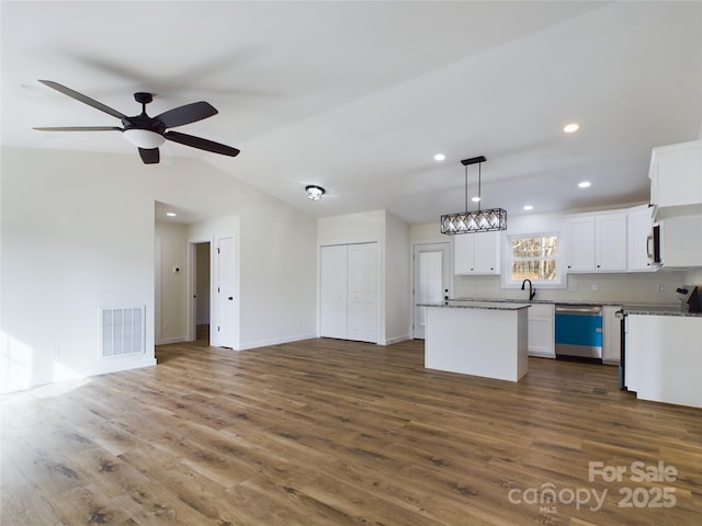 kitchen featuring open floor plan, a kitchen island, visible vents, and white cabinetry