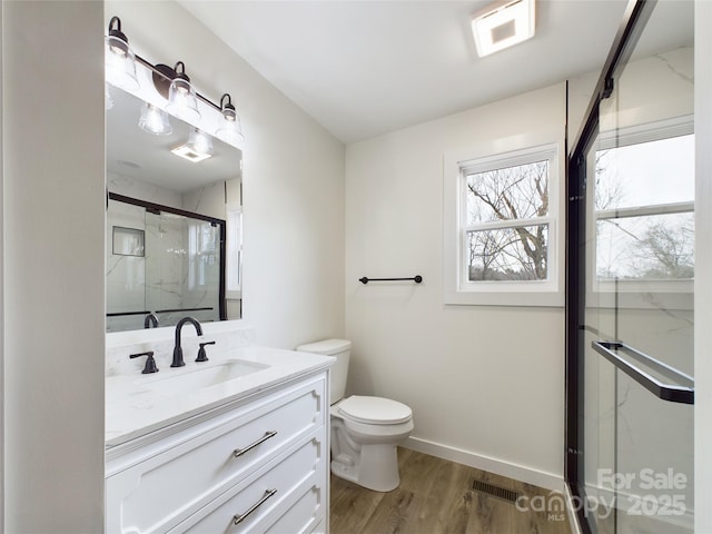 full bathroom featuring a marble finish shower, visible vents, baseboards, wood finished floors, and vanity