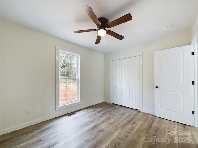 unfurnished bedroom with light wood-style flooring, a closet, visible vents, and baseboards