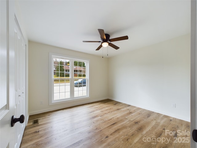 unfurnished room featuring ceiling fan, light wood finished floors, visible vents, and baseboards