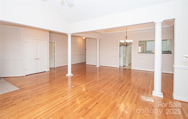 interior space with baseboards, high vaulted ceiling, decorative columns, and light wood-style floors